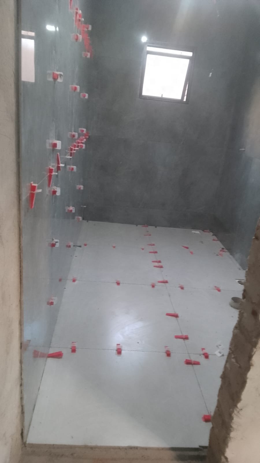 Banheiro com piso e azulejo assentados com espaçadores de nivelamento